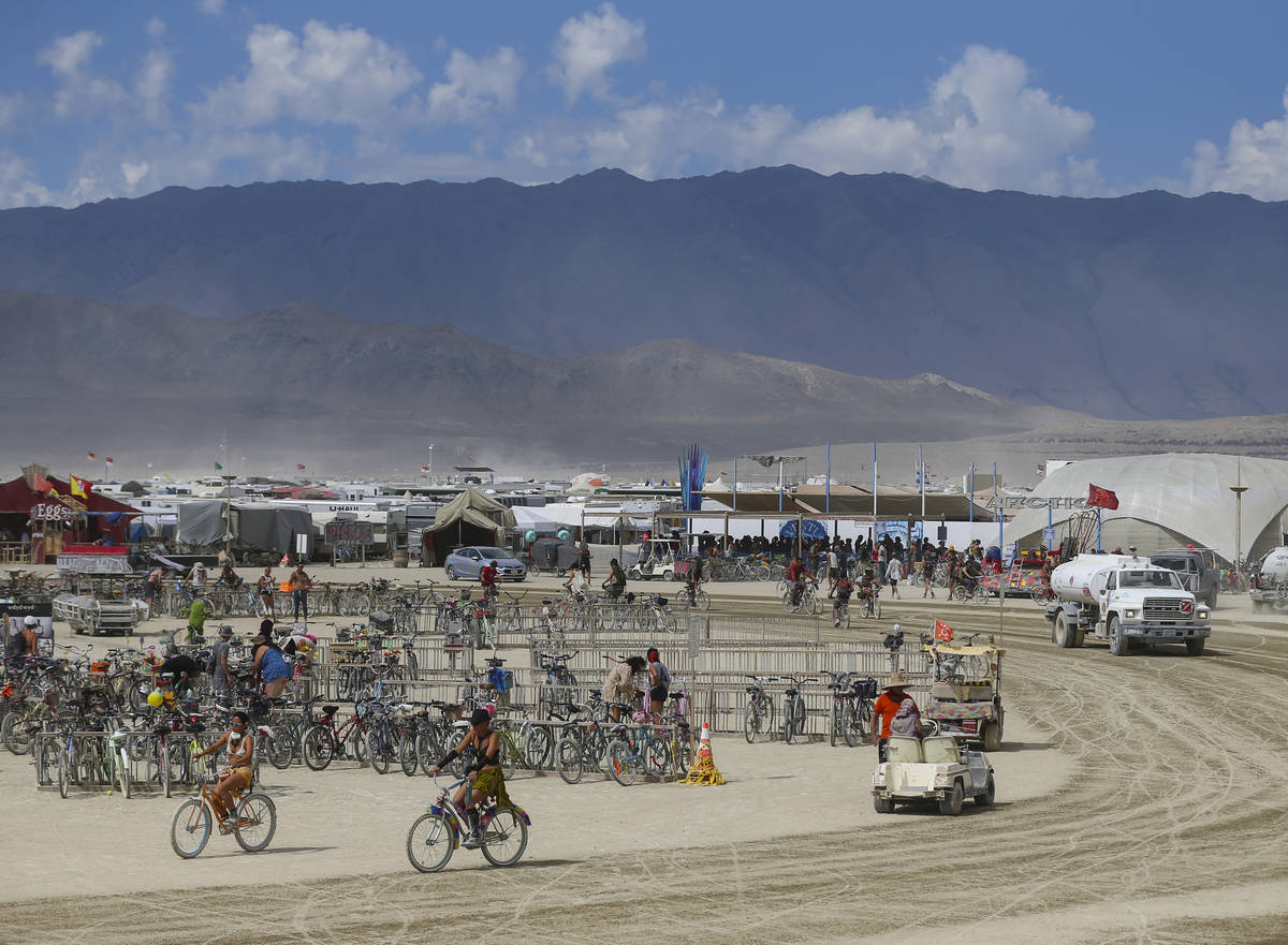 Attendees pass through the center camp area during Burning Man at the Black Rock Desert north o ...