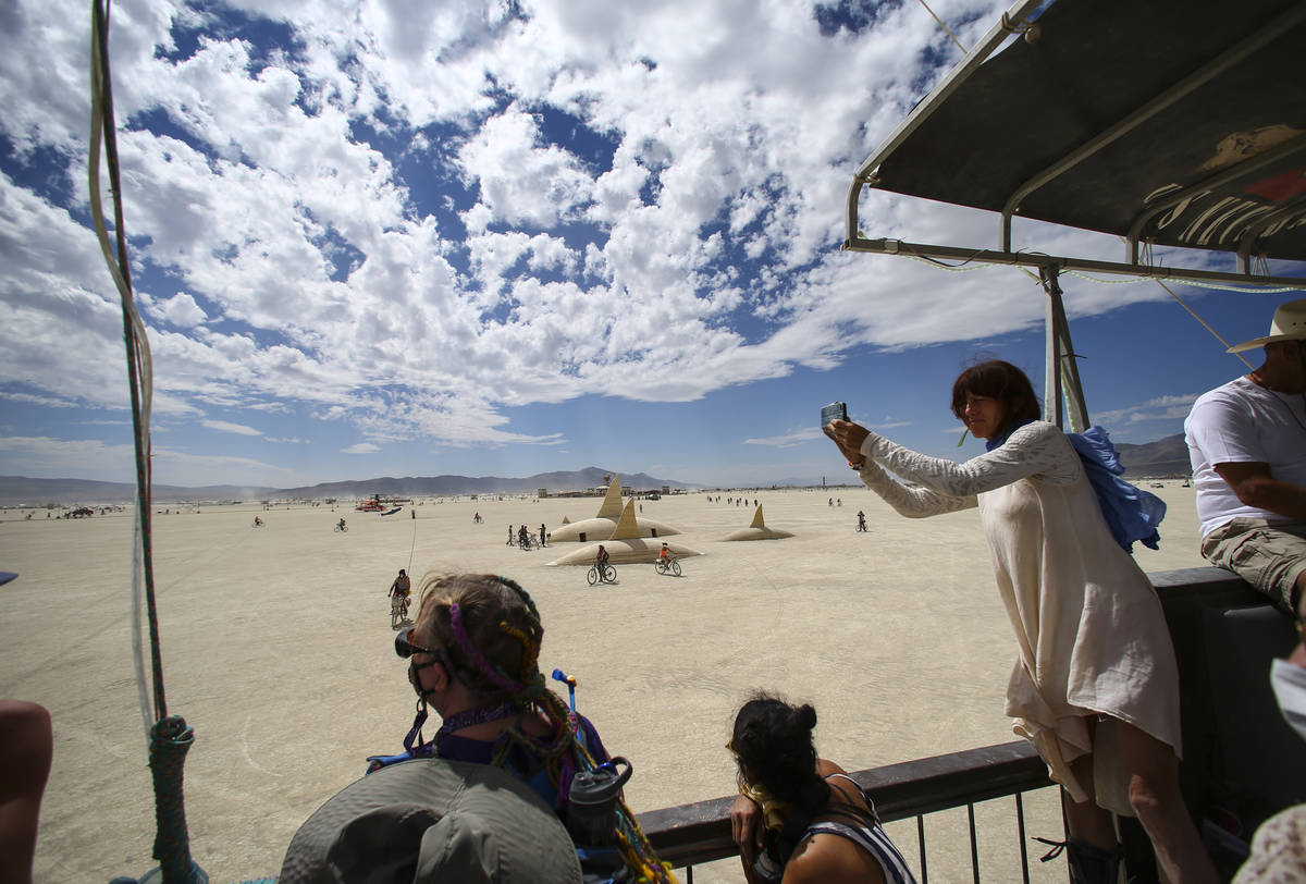 Attendees aboard the USS Nevada art car taken the sights during Burning Man at the Black Rock D ...