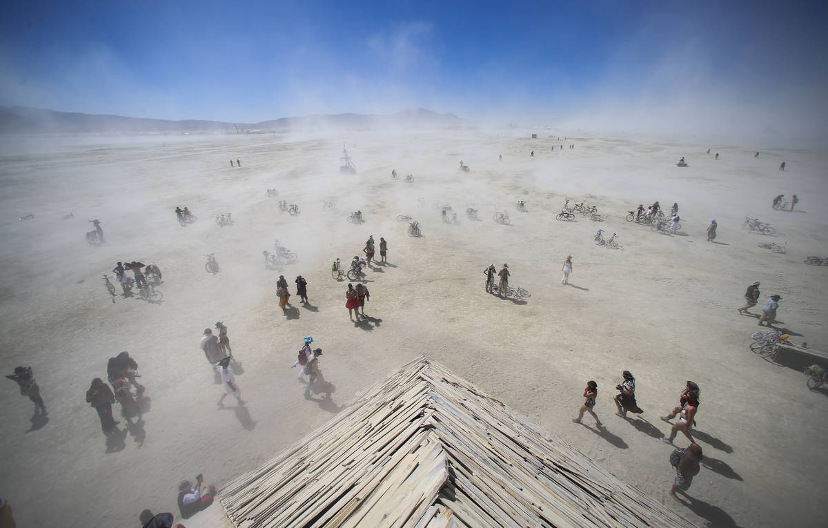 Attendees approach the Catacomb of Veils art installation as dust kicks up along the playa duri ...