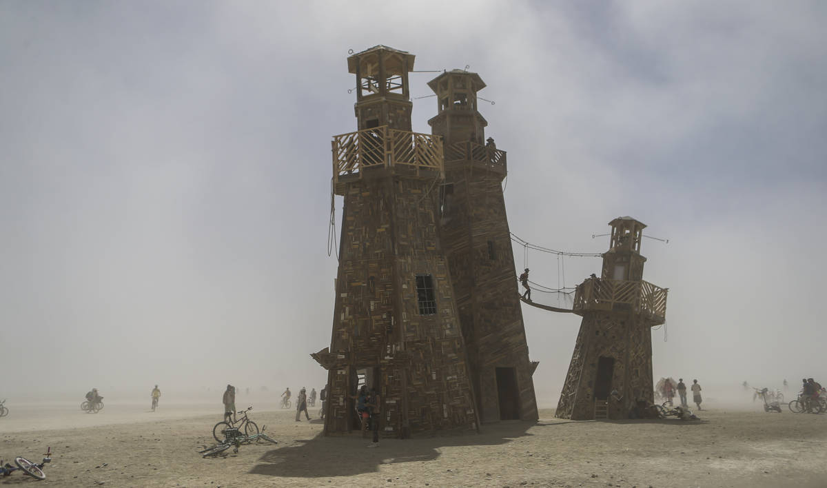 Attendees explore The Black Rock Lighthouse Service art installation during Burning Man at the ...