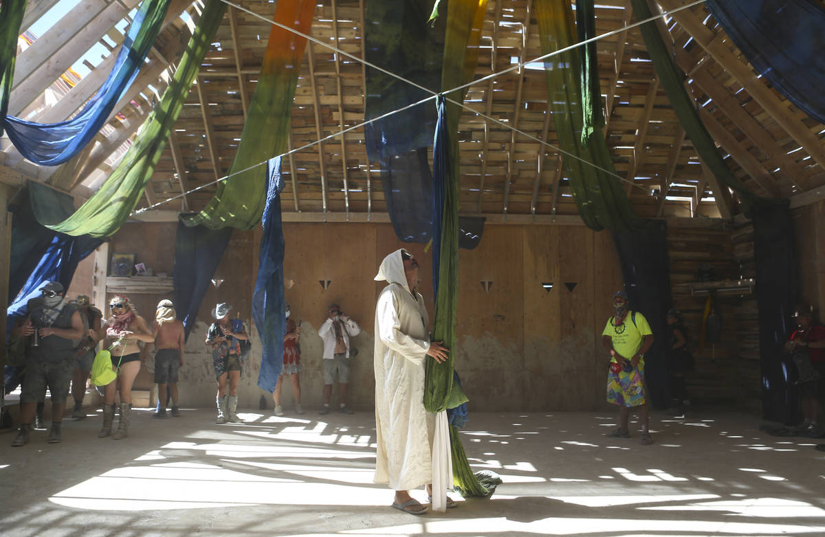 Luis Navarrete, center, of Portland, Ore., walks through the Catacomb of Veils art installation ...