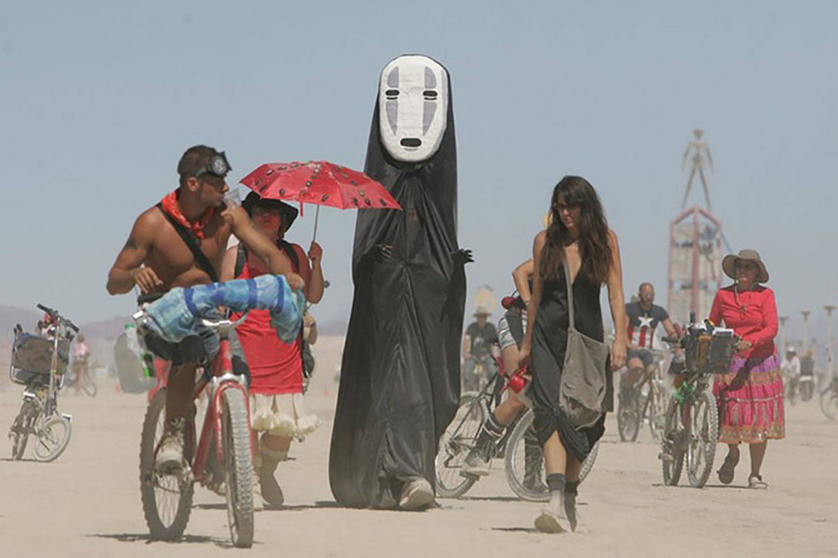 Burning Man participants walk on the playa at the Black Rock Desert near Gerlach in 2008. (Bra ...