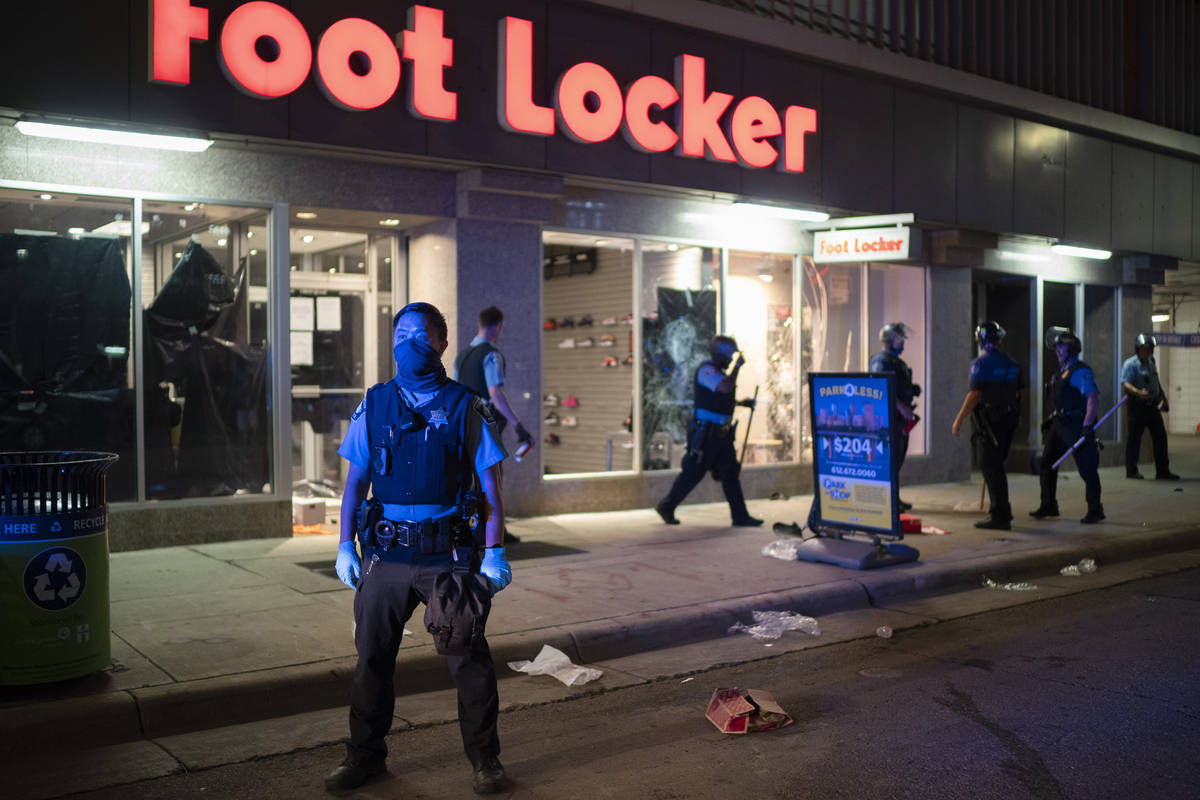 Minneapolis Police stand outside a looted Foot Locker store on S. 7th St., Wednesday, Aug. 26, ...