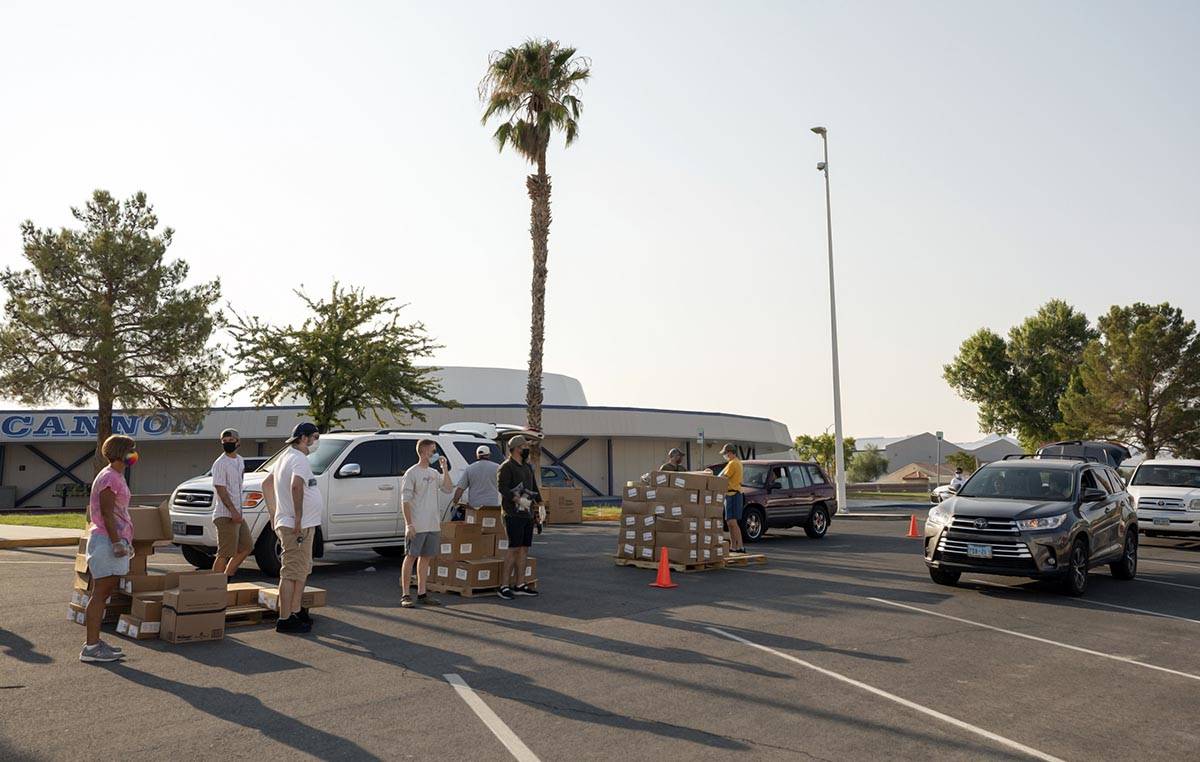 Volunteers with Three Square Food Bank distribute meals at Cannon Junior High School for the co ...