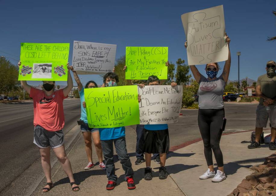 Parents and students stand on the sidewalk outside the County School District Administration Ce ...