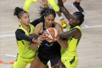 Las Vegas Aces' A'ja Wilson, center, is defended by Seattle Storm's Alysha Clark, left, and Nat ...