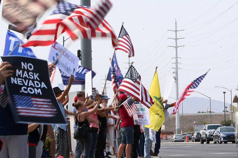 People attend a No Mask Nevada PAC rally at the intersection of Eastern Avenue and Pebble Road ...