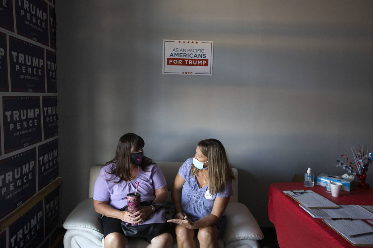 Women for Trump members Randi Parks, left, and Janet Webb, right, chat during a watch party for ...