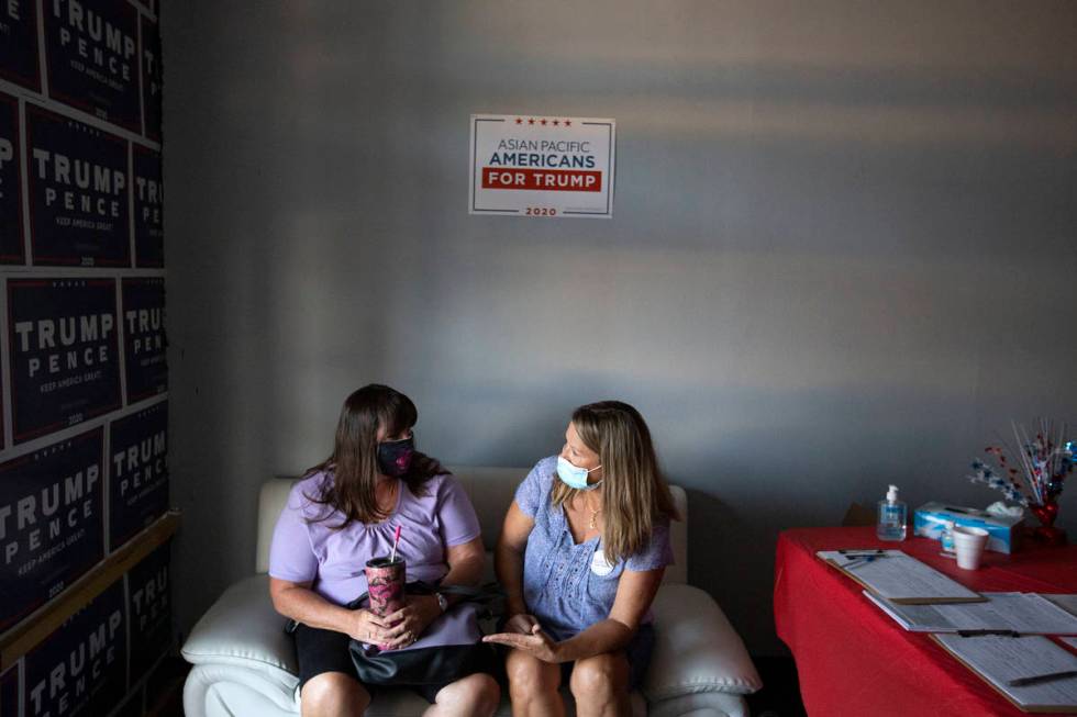 Women for Trump members Randi Parks, left, and Janet Webb, right, chat during a watch party for ...