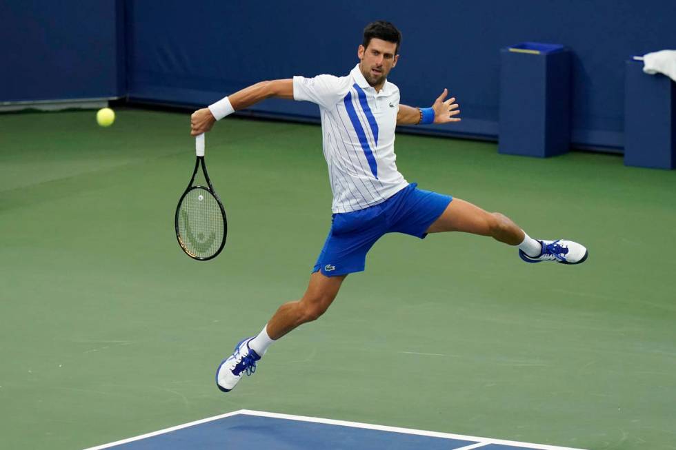 Novak Djokovic, of Serbia, returns a shot to Milos Raonic, of Canada, during the finals of the ...