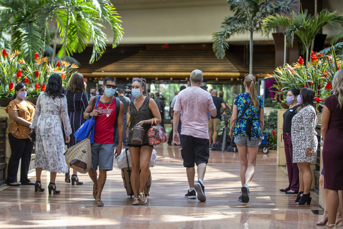 Guests make their way through the atrium as the Mirage reopens following a COVID-19 shutdown on ...