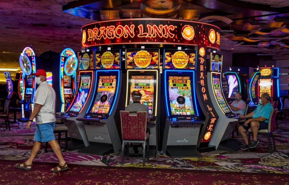 Guests play some slot machines as the Mirage reopens following a COVID-19 shutdown on Thursday, ...