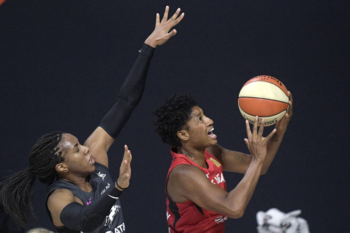 Las Vegas Aces forward Angel McCoughtry, right, goes up for a shot in front of Dallas Wings for ...