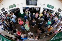 In this May 3, 2014, file photo, taken with a fisheye lens, fans line up to place bets before t ...