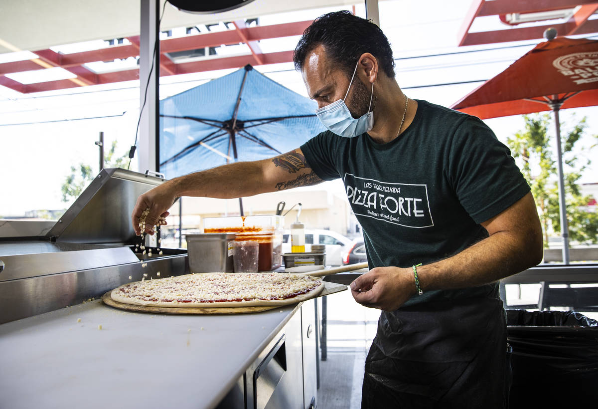 Mimmo Ferraro, owner and chef at Pizza Forte, right, prepares a pizza in the University Gateway ...