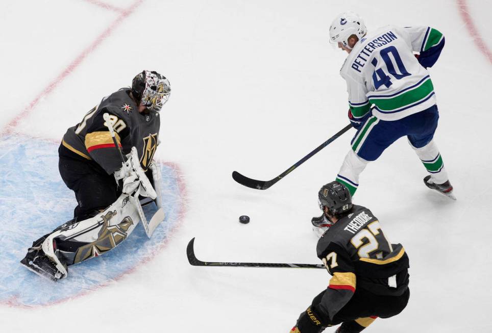 Vegas Golden Knights goalie Robin Lehner (90) stops Vancouver Canucks' Elias Pettersson (40) as ...