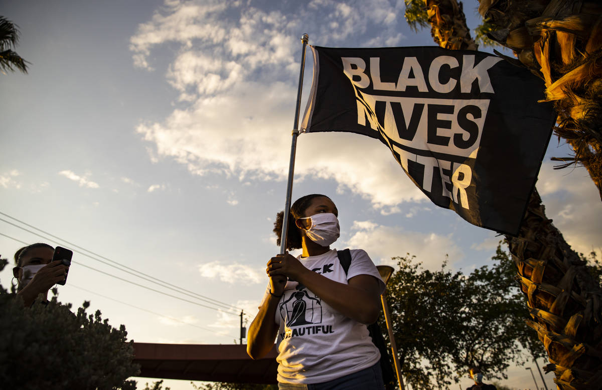 Renati Hackley, of North Las Vegas, holds a Black Lives Matter flag during a rally against poli ...