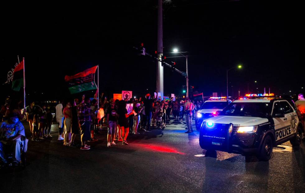 People stop traffic as police look on during a rally against police brutality by the Martin Lut ...