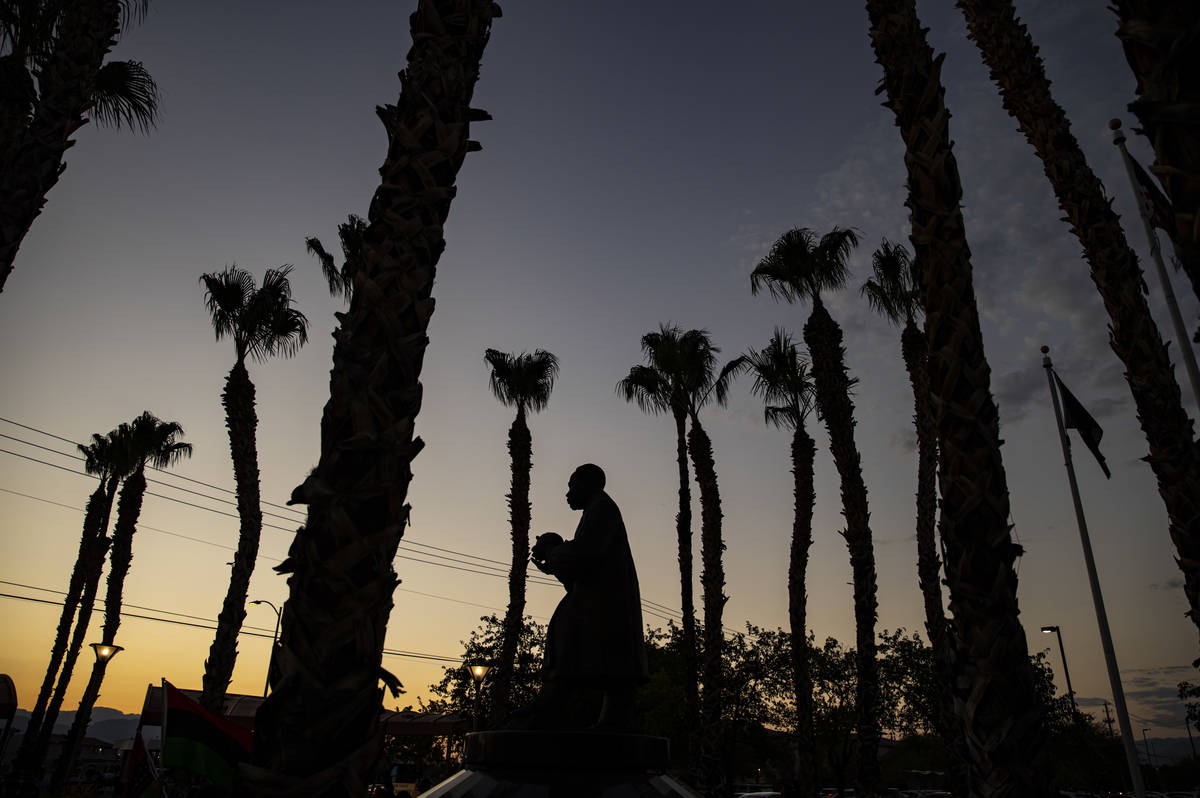 The Martin Luther King Jr. statue in North Las Vegas is silhouetted against the sky during a ra ...