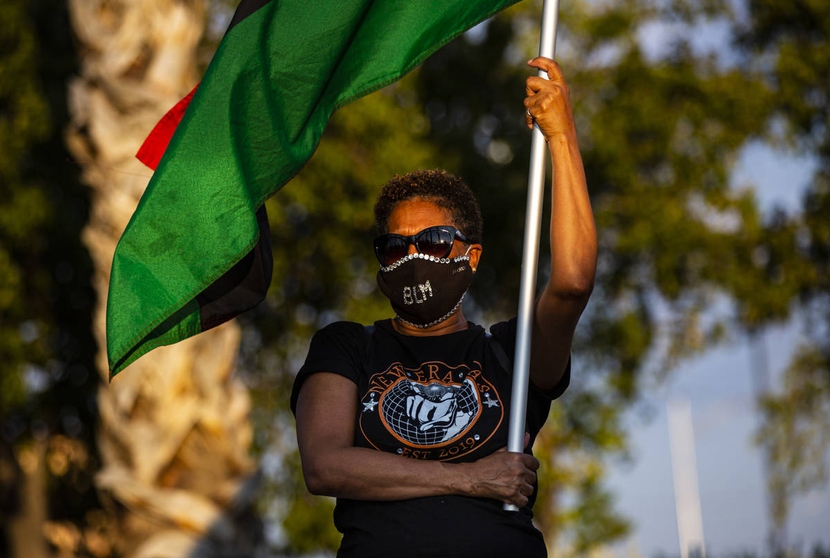 Hilary Thomas, of Henderson, holds up a flag during a rally against police brutality in North L ...