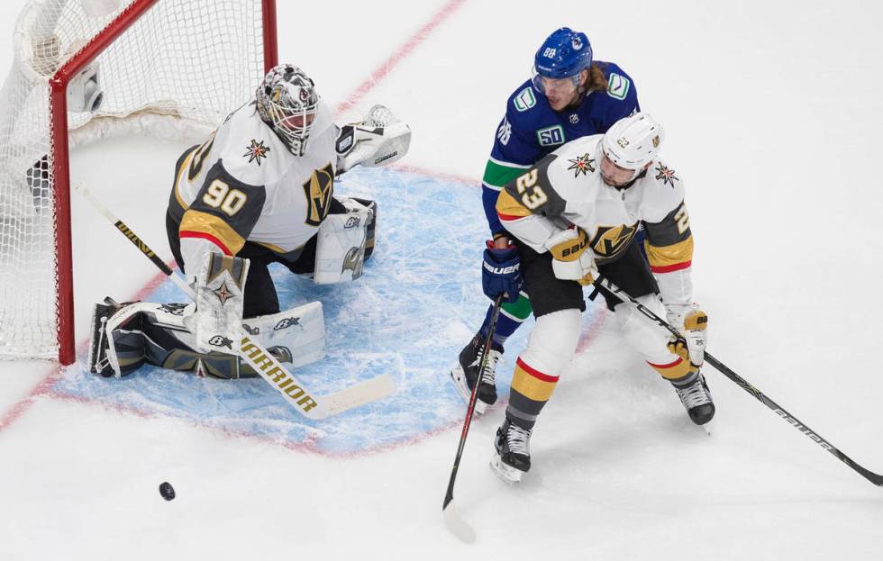 Vegas Golden Knights goaltender Robin Lehner (90) makes a save as Vancouver Canucks center Adam ...