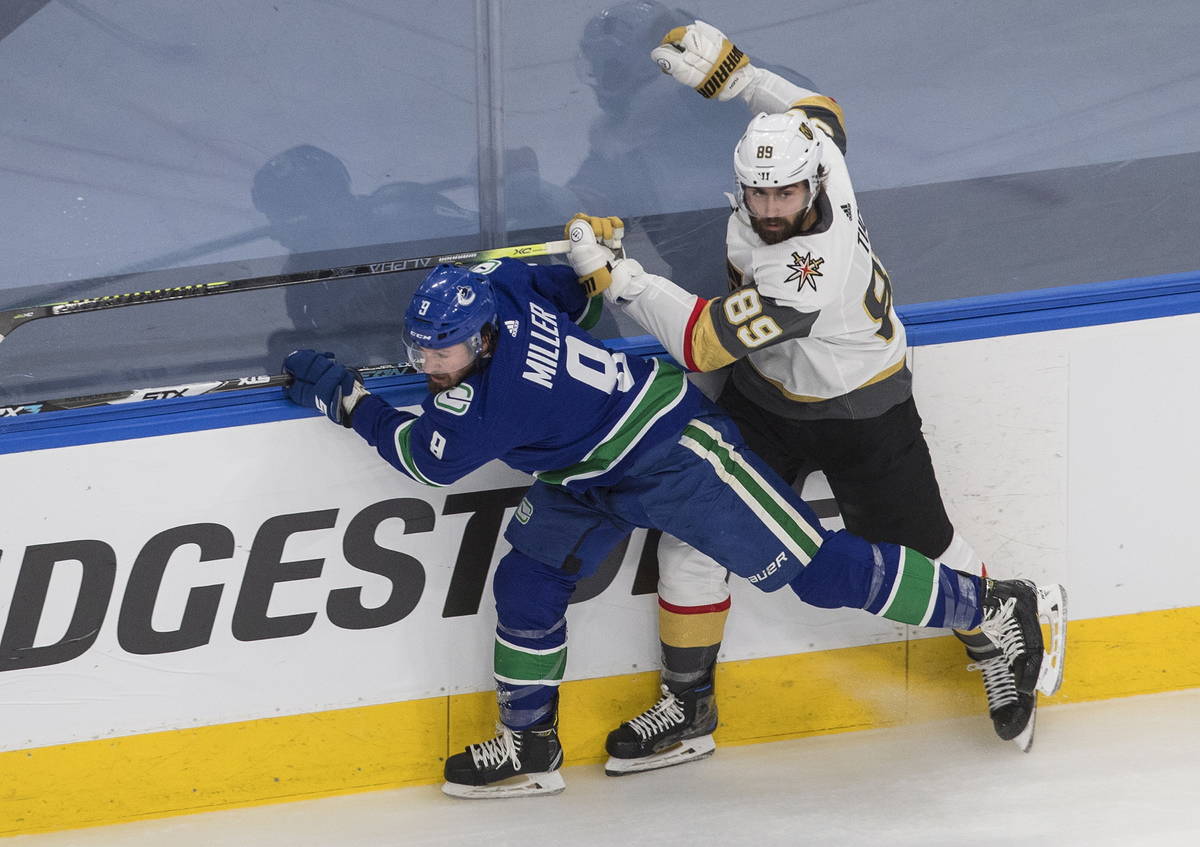 Vegas Golden Knights' Alex Tuch (89) checks Vancouver Canucks centre J.T. Miller (9) during the ...