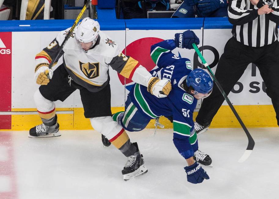 Vegas Golden Knights defenseman Brayden McNabb (3) checks Vancouver Canucks defenceman Troy Ste ...