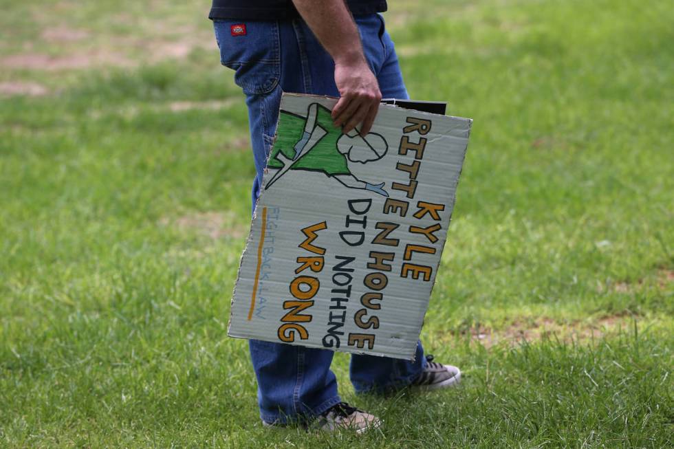 A man participating in a No Mask Nevada PAC rally displays a sign at Sunset Park in Las Vegas, ...