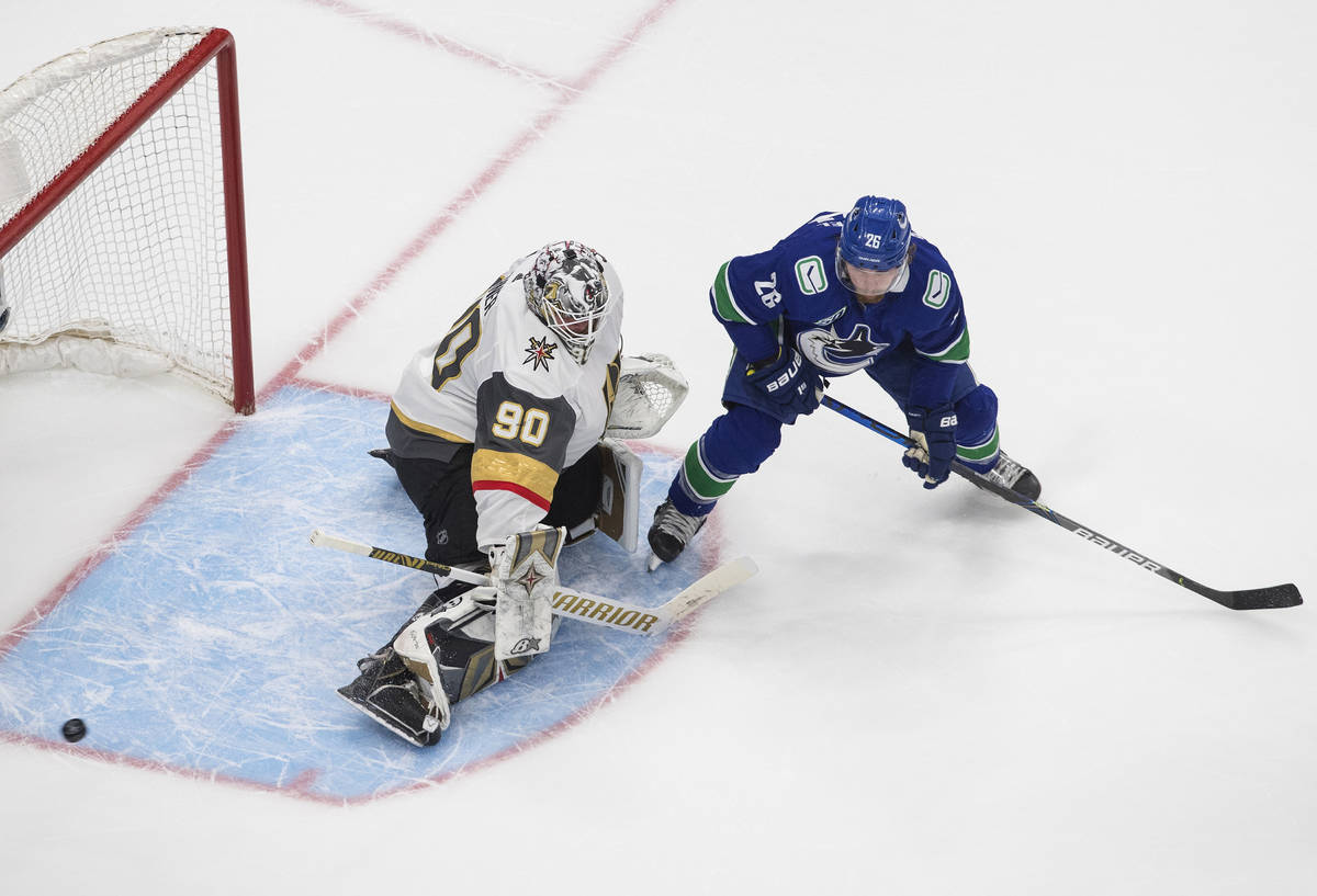 Vegas Golden Knights goalie Robin Lehner (90) makes a save on Vancouver Canucks' Antoine Rousse ...