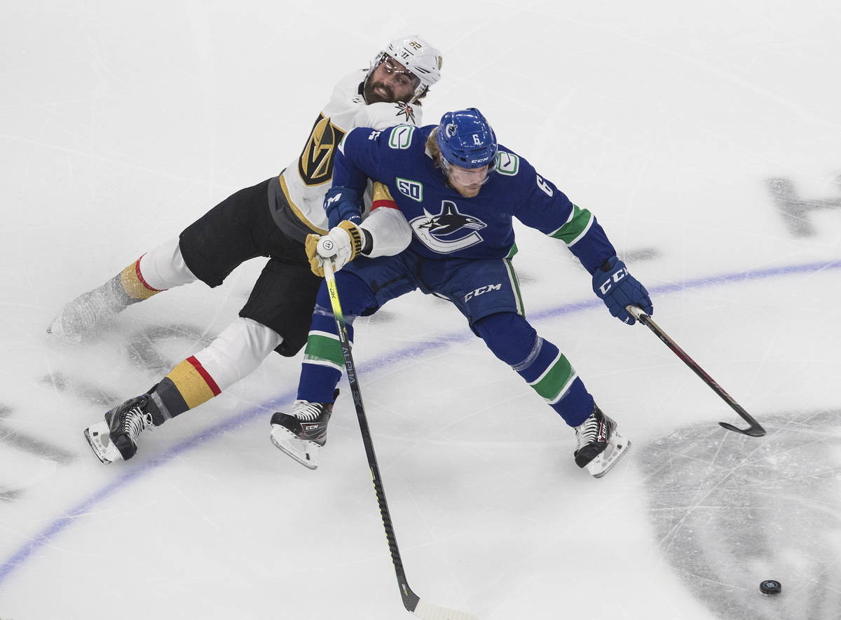 Vegas Golden Knights' Alex Tuch (89) and Vancouver Canucks' Brock Boeser (6) battle for the puc ...