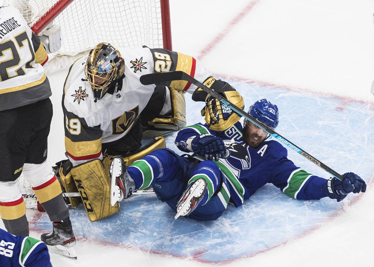 Vegas Golden Knights goalie Marc-Andre Fleury (29) is crashed into by Vancouver Canucks' Brando ...