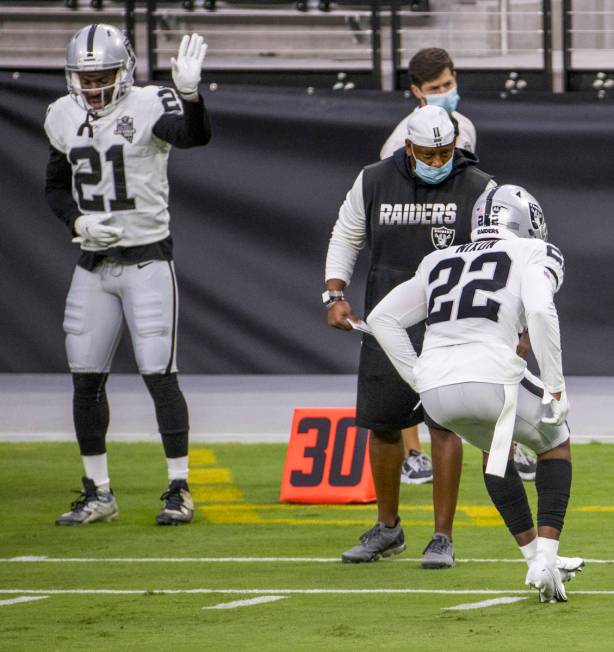 Las Vegas Raiders cornerback Prince Amukamara (21, left) raises his hand as cornerback Keisean ...