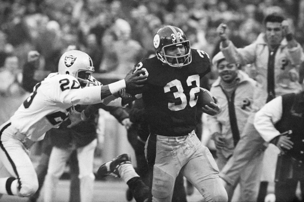 The Steelers’ Franco Harris eludes the Raiders’ Jimmy Warren en route to his “Immaculate ...