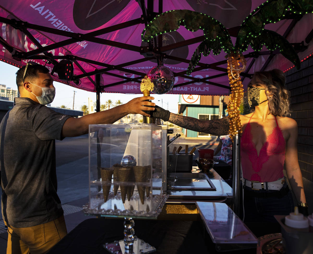 Founder and head creamstress Valerie Stunning, right, hands Elijah Armstrong an ice cream cone ...