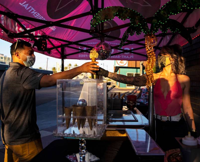 Founder and head creamstress Valerie Stunning, right, hands Elijah Armstrong an ice cream cone ...