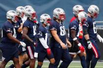 New England Patriots players take the field before an NFL football training camp scrimmage, Fri ...