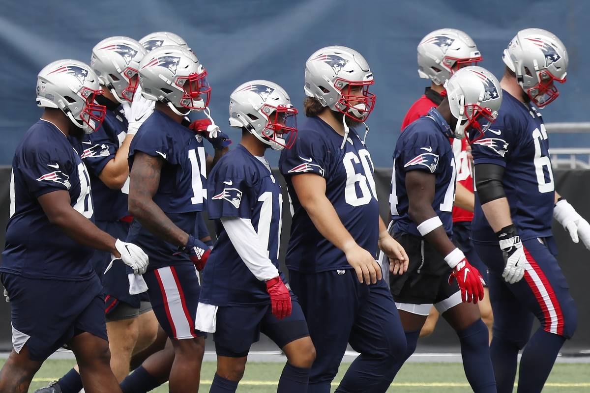 New England Patriots players take the field before an NFL football training camp scrimmage, Fri ...