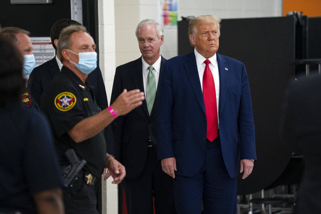 President Donald Trump listens to Kenosha County Sheriff David Beth at the emergency operations ...