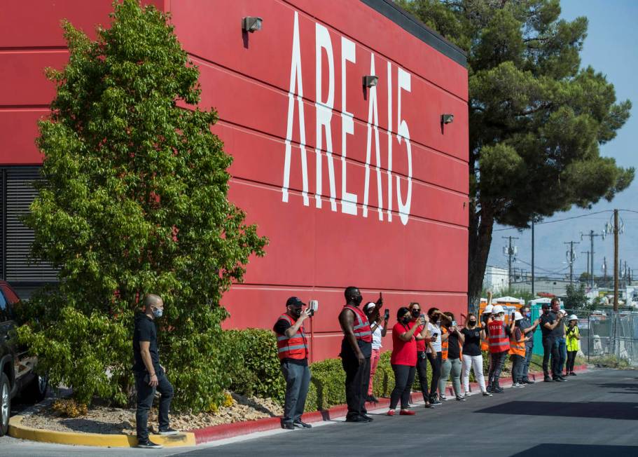 Attendees watch as the caravan including Henry Chang's art cars, an Area15 mobile billboard and ...