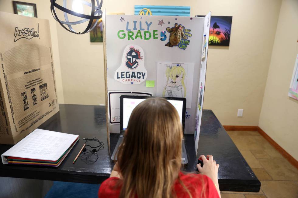 Lily Larrabee, 10, a student at Legacy Traditional School, works on her school work from her ho ...