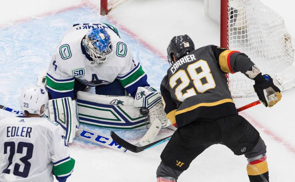 Vancouver Canucks goalie Thatcher Demko (35) makes a save on Vegas Golden Knights' William Carr ...