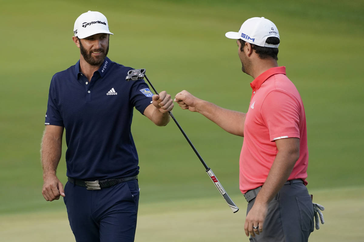 Jon Rahm, right, is congratulated by Dustin Johnson on the first playoff hole during the final ...
