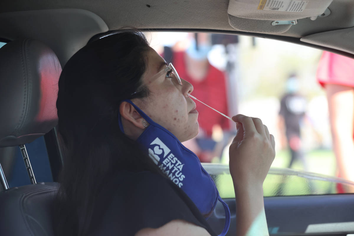 Beatriz Martinez takes a self-administered COVID-19 test at the new "Stop, Swab and Go" COVID-1 ...