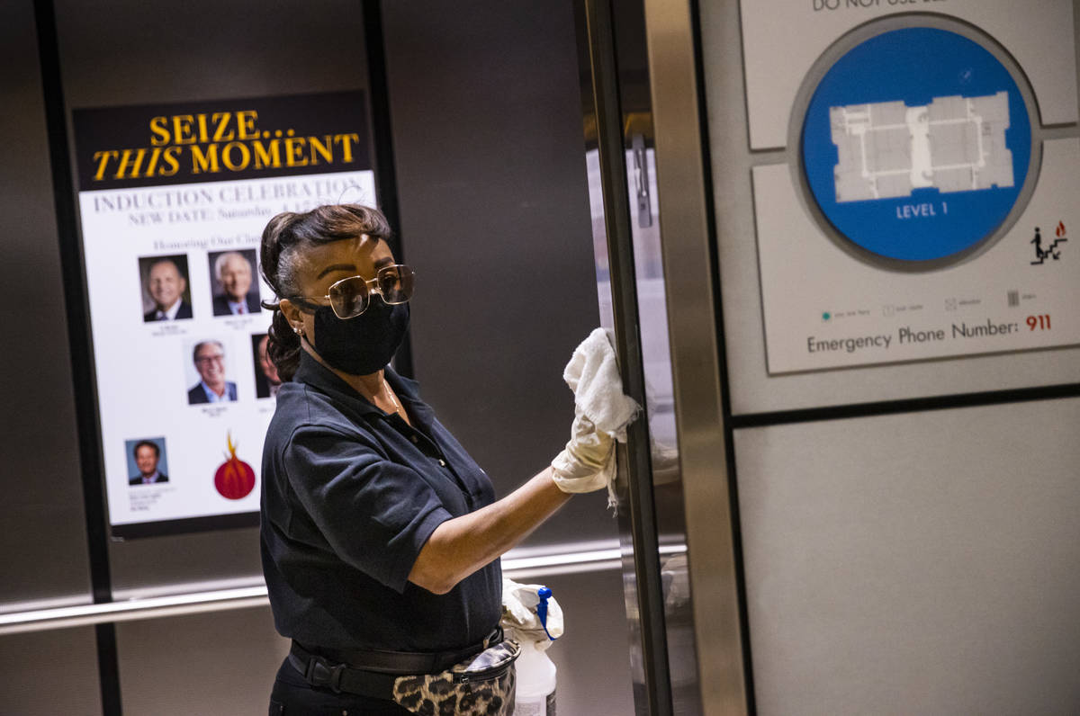 Louvenia Madison sanitizes elevators during the Summer Las Vegas Market at the World Market Cen ...