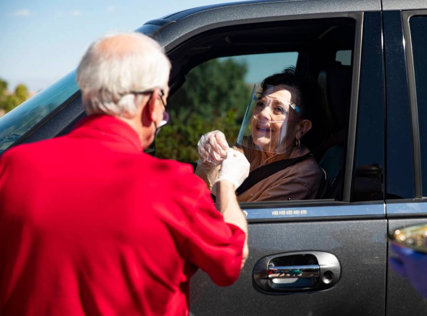 Pastor David Miller offers a Communion wafer to Shelle McIntyre during a Sunday morning drive- ...