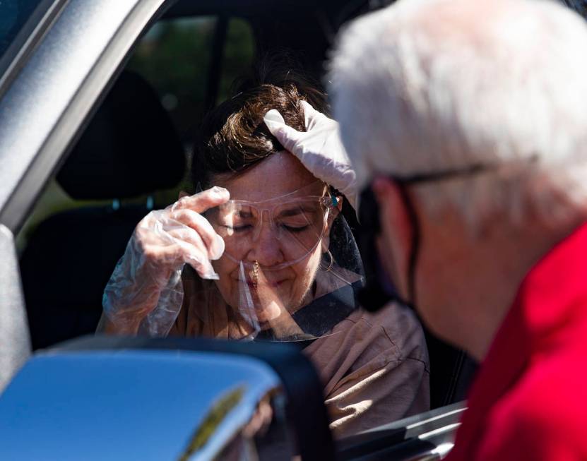 Pastor David Miller prays over Shelle McIntyre during a drive-through Communion service at New ...
