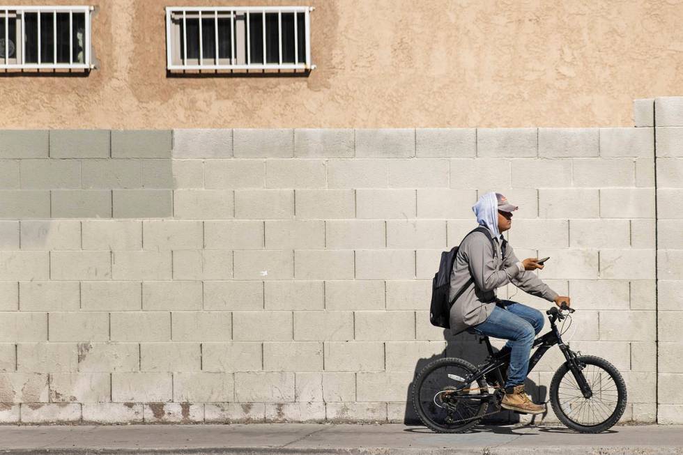 A man rides a bike on the sidewalk north on Pecos Road on Wednesday, Sept. 2, 2020, in North La ...