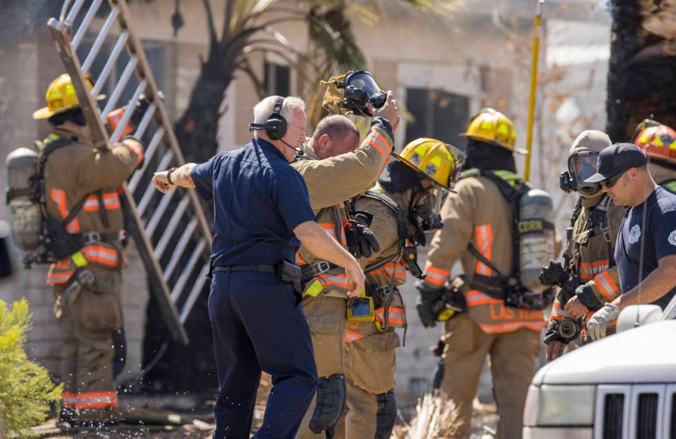 Las Vegas firefighters make a plan as they battle a house fire on 5400 block of West Pebble Bea ...