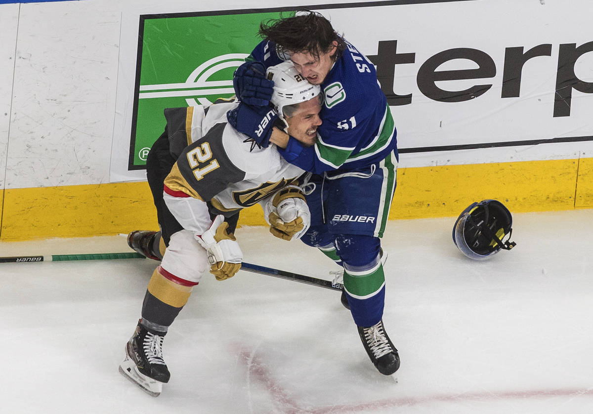 Vancouver Canucks' Troy Stecher (51) and Vegas Golden Knights' Nick Cousins (21) wrestle during ...