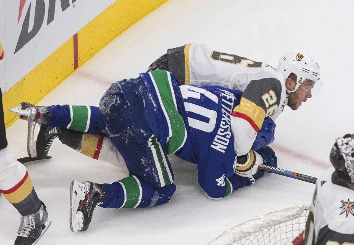Vancouver Canucks' Elias Pettersson (40) and Vegas Golden Knights' Paul Stastny (26) rough it u ...